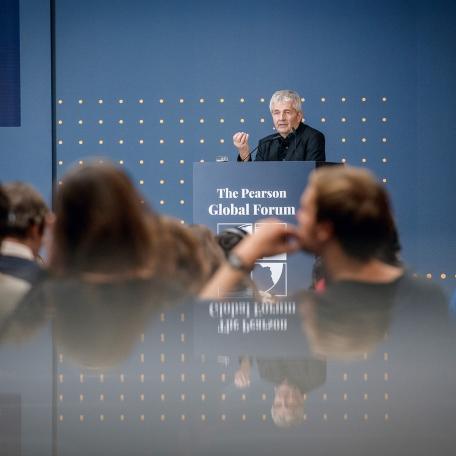 Man gives presentation on stage at the Pearson Global Forum