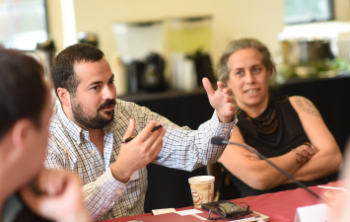 Pearson Faculty Affiliate Austin Wright, Assistant Professor at Harris Public Policy, speaks with colleagues at Harris Public Policy.